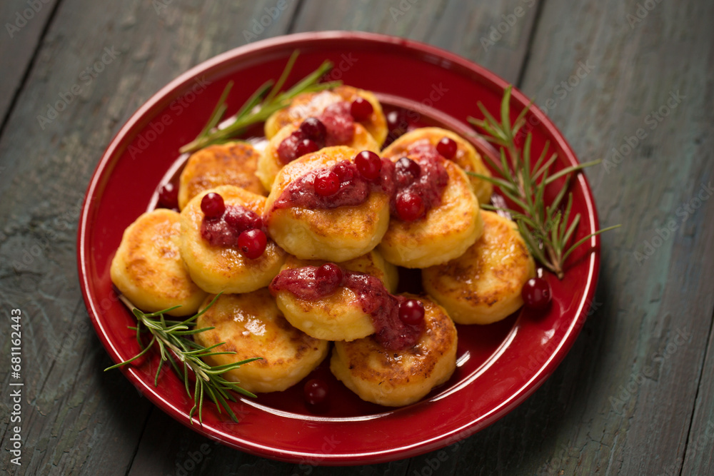 Delicious Cheese pancakes decorated with rosemary and cranberries, a homemade Christmas dessert Delicious Cheese pancakes decorated with rosemary and cranberries, a homemade Christmas dessert