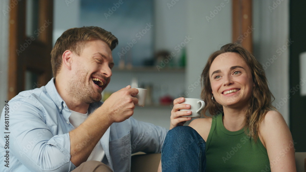Laughing lovers coffee cups holding at home closeup. Carefree spouses having fun Laughing lovers coffee cups holding at home closeup. Carefree spouses having fun