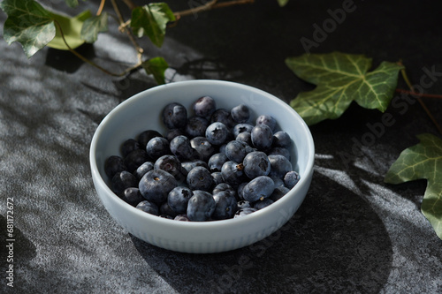 blueberries in a ceramic bowl on a dark gray background, close-up, no people