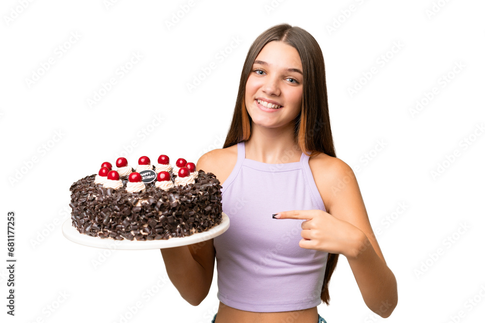 Teenager caucasian girl holding birthday cake over isolated background and pointing it Teenager caucasian girl holding birthday cake over isolated background and pointing it