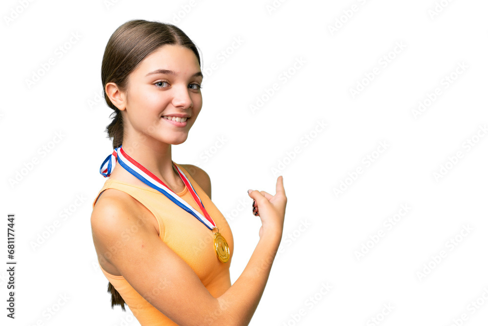 Teenager caucasian girl with medals over isolated background pointing back Teenager caucasian girl with medals over isolated background pointing back