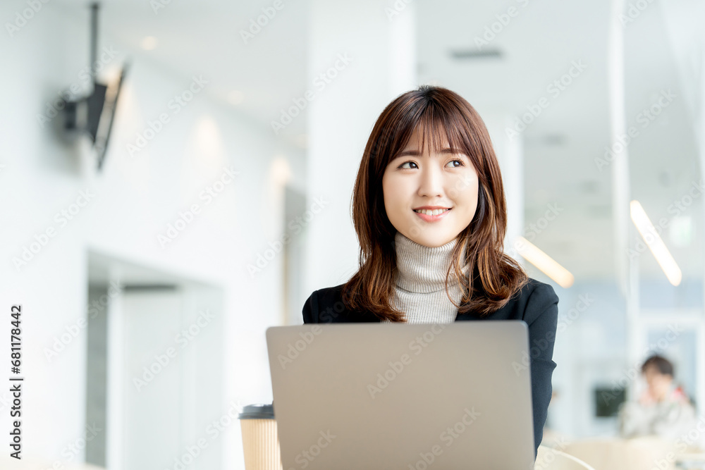パソコンを使う笑顔のビジネスウーマン