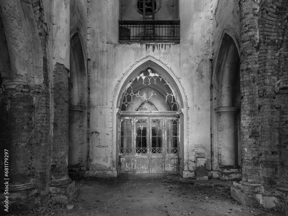 central view to arch and door inside abandoned church in black and white style