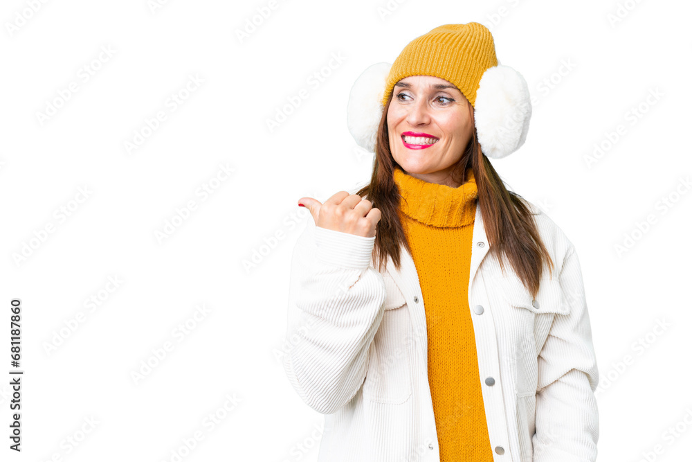 Middle age woman wearing winter muffs over isolated chroma key background pointing to the side to present a product Middle age woman wearing winter muffs over isolated chroma key background pointing to the side to present a product