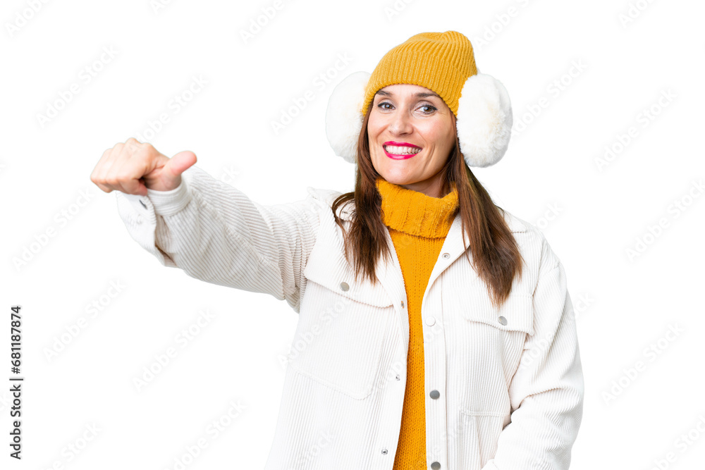 Middle age woman wearing winter muffs over isolated chroma key background giving a thumbs up gesture Middle age woman wearing winter muffs over isolated chroma key background giving a thumbs up gesture