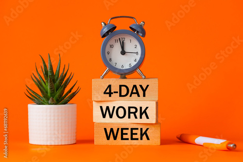 Symbol of a 4-day working week. Desk with wooden blocks with the words 4-day work week, seculant, pen, beautiful orange background. Copy space. Business concept, change from 5 to 4 day work week
