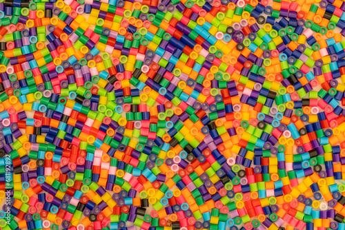 Pile of multicoloured bright Hama beads also known as craft beads for making cute designs before ironing for pile. Colorful industrial plastic granules background © Leszek Szelest