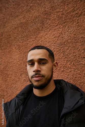 Fotografie Portrait of a biracial man standing against a textured wall