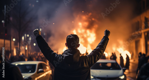 Concept protesters riot people. Back view Aggressive man without face in hood against backdrop of protests and burning cars