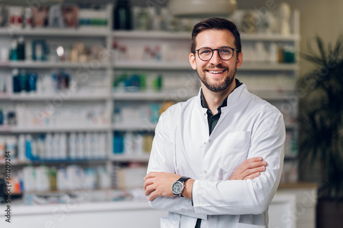 Fotografie Portrait of a happy pharmacy shop owner standing in the drug store and smiling at the camera
