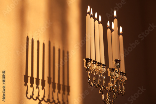 Closeup of Hanukkah menorah, or hanukkiah in the light of the sun at sunset for Jewish holiday Hanukkah. Hanukkah lamp, nine-branched candelabrum with burning candles.