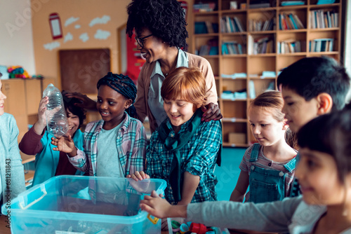 Children learning how to recycle plastic in elementary classroom