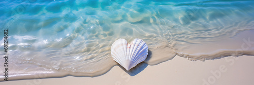 white heart shaped seashell lying in the sand with the blue sea and soft waves in background