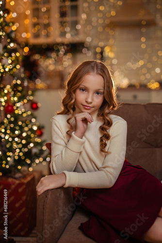 New Year's traditions. beautiful cute girl on the sofa at home in the interior of the kitchen near the Christmas tree