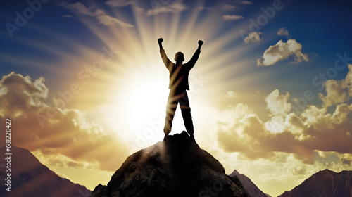 silhouette of a person on the top of mountain rising his fist as gesture for success photo