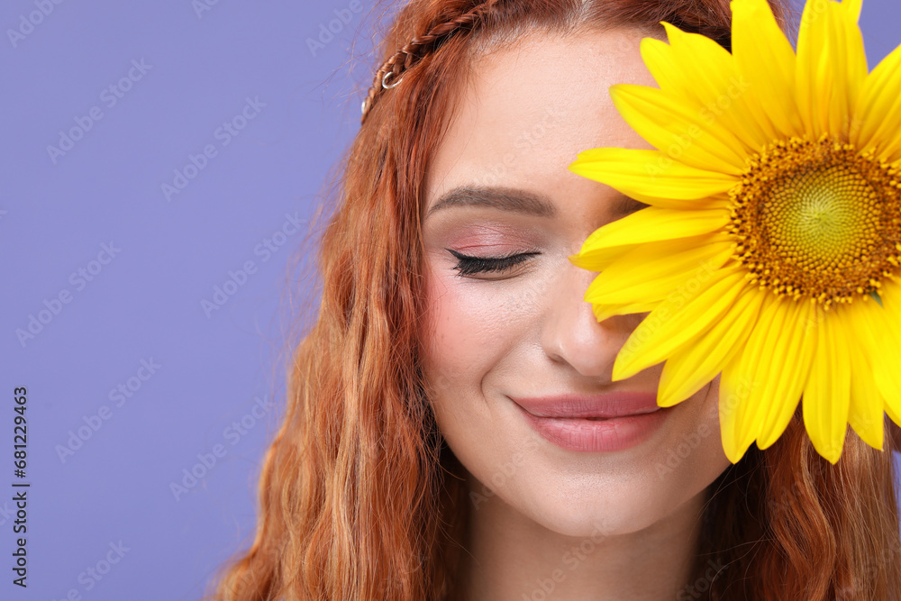 Beautiful young hippie woman covering eye with sunflower on violet background, closeup Beautiful young hippie woman covering eye with sunflower on violet background, closeup