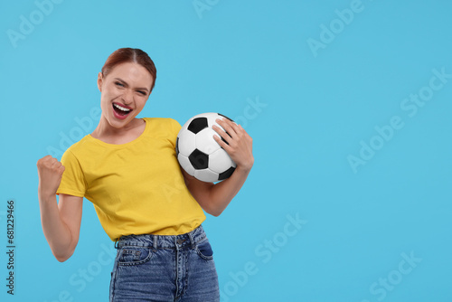 Emotional fan holding football ball and celebrating on light blue background, space for text © New Africa