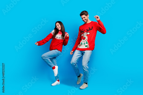 Full length photo of lovely young spouses energetic dancing have fun wear x-mas ornament red sweaters isolated on blue color background