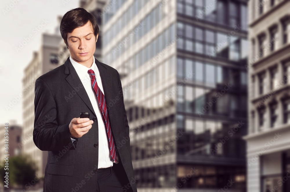 Young happy businessman standing in city street Young happy businessman standing in city street