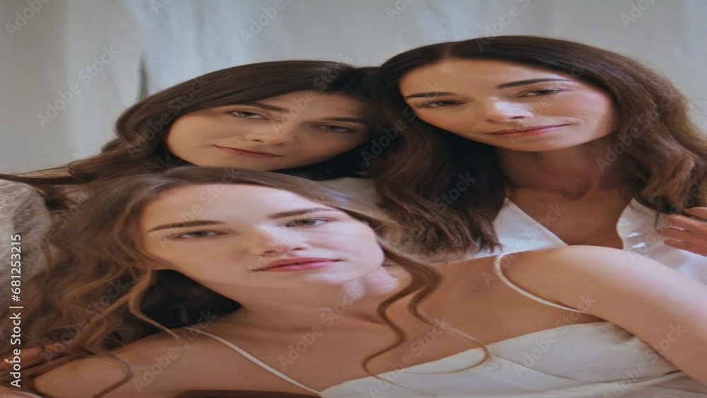 Smiling family portrait looking camera. Three models sisters embracing vertical Smiling family portrait looking camera. Three models sisters embracing vertical