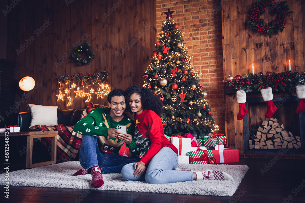 Photo of two people friends wife husband in decorated apartment indoors using smart cell gadget browsing season tradition sales Photo of two people friends wife husband in decorated apartment indoors using smart cell gadget browsing season tradition sales