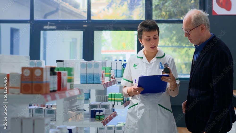 Obraz premium Elderly man in need of prescription drugs informations in apothecary, asking chemist checking medicinal products inventory. Pharmacy technician helping senior client with advice
