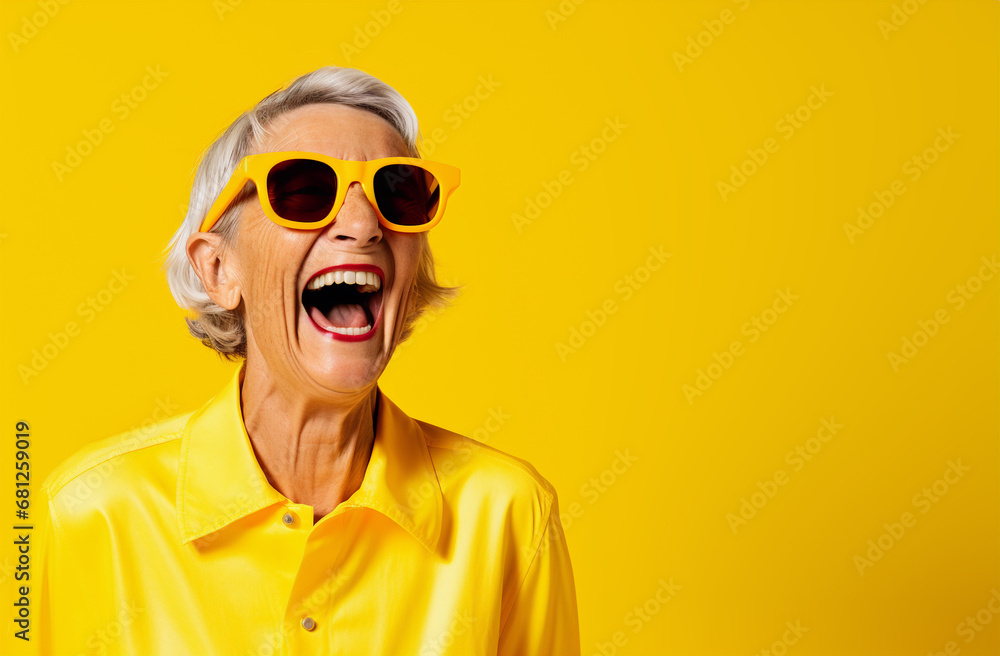 An happy elderly woman wearing sunglasses laughs out loud in front of a yellow background - Generative AI An happy elderly woman wearing sunglasses laughs out loud in front of a yellow background - Generative AI