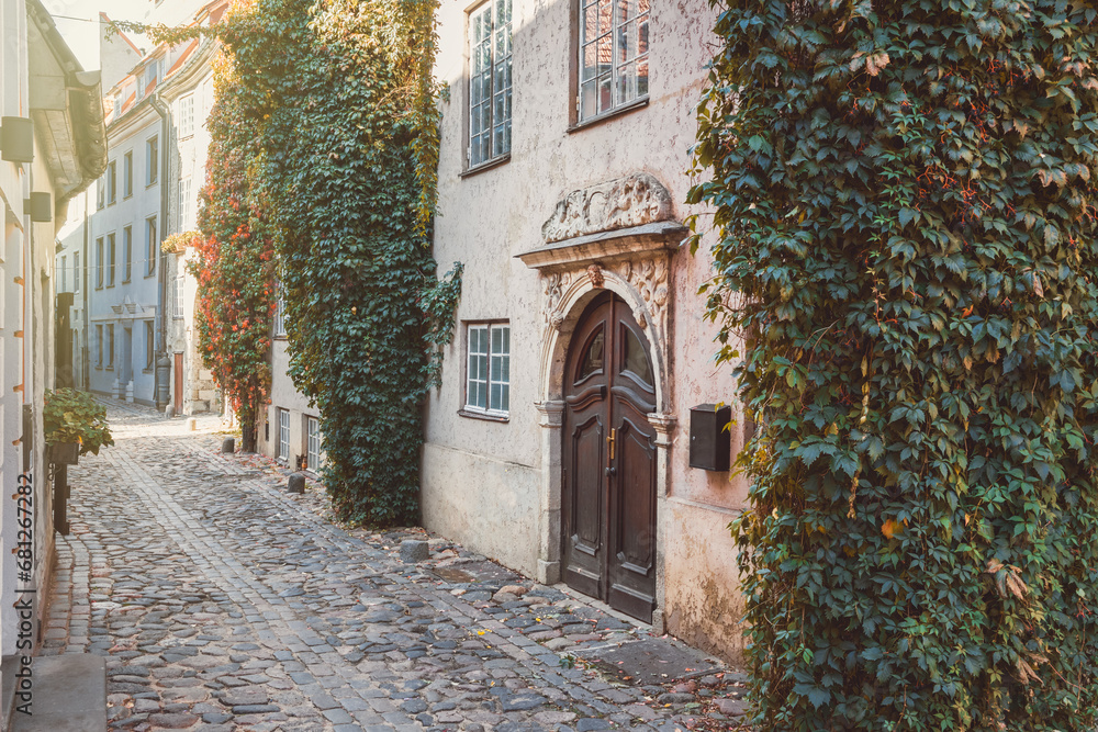 Fototapeta premium Old medieval narrow street in the fall. Old town of Riga, Latvia. Retro styled.