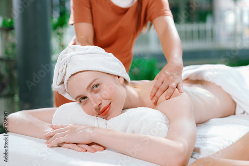 Couple of beautiful young woman lie on white spa bed during having back massage. Attractive caucasian woman having back massage at traditional spa room. Relaxing and healthy concept Tranquility.