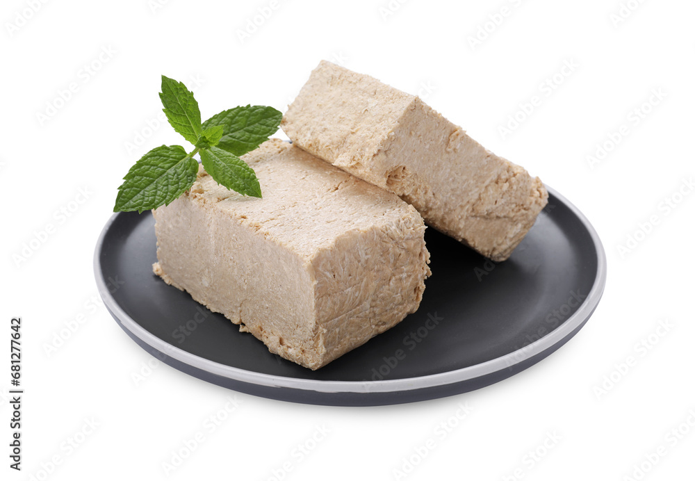 Plate with pieces of tasty halva and mint isolated on white Plate with pieces of tasty halva and mint isolated on white