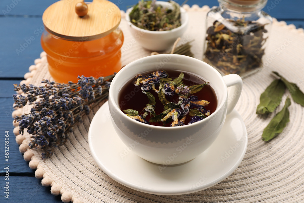 Aromatic tea with different dry herbs and honey on blue wooden table, closeup Aromatic tea with different dry herbs and honey on blue wooden table, closeup