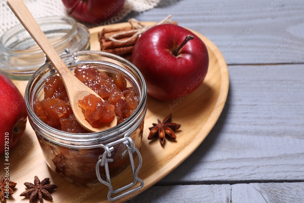 Delicious apple jam in jar, fresh fruits and spices on grey wooden table. Space for text Delicious apple jam in jar, fresh fruits and spices on grey wooden table. Space for text