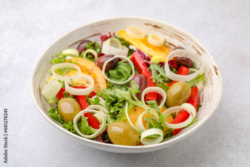 Bowl of tasty salad with leek and olives on light table Bowl of tasty salad with leek and olives on light table