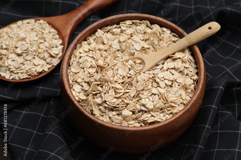 Bowl with scoop and spoon of oatmeal on table, closeup Bowl with scoop and spoon of oatmeal on table, closeup