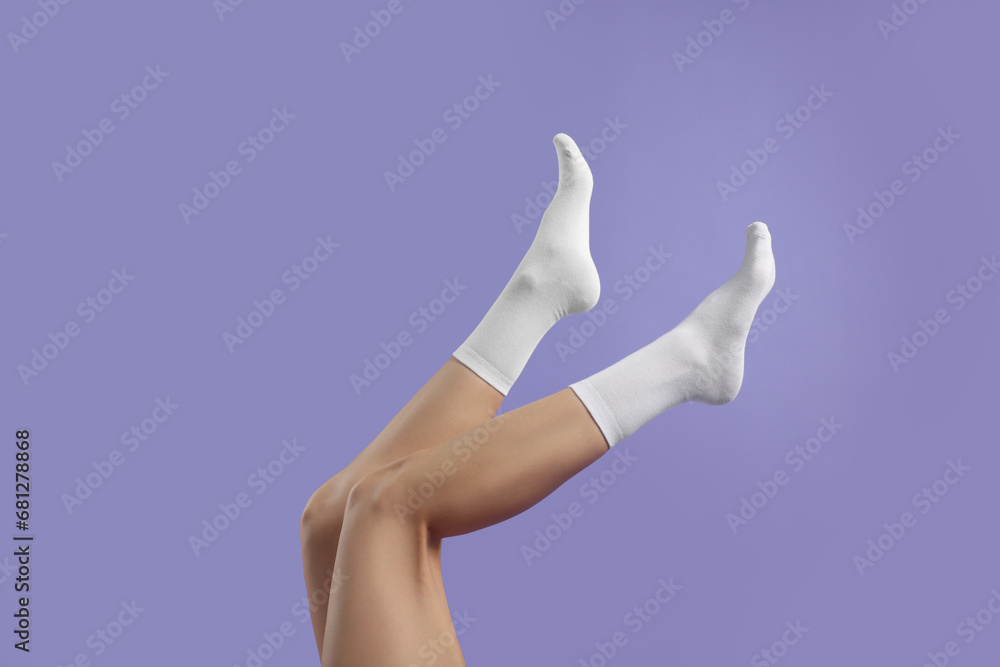 Woman in stylish white socks on violet background, closeup Woman in stylish white socks on violet background, closeup