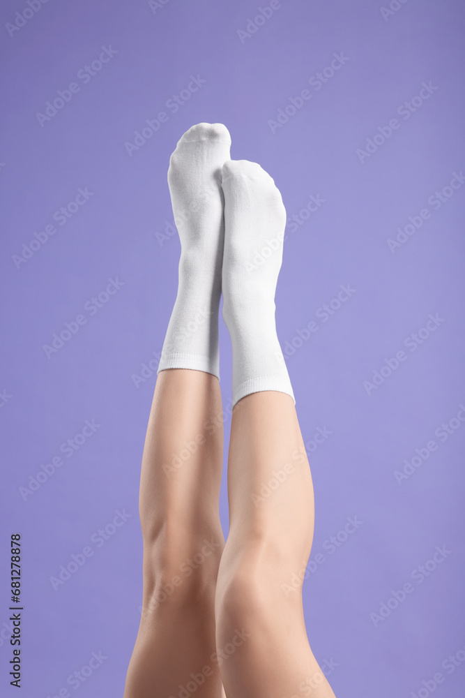 Woman in stylish white socks on violet background, closeup Woman in stylish white socks on violet background, closeup