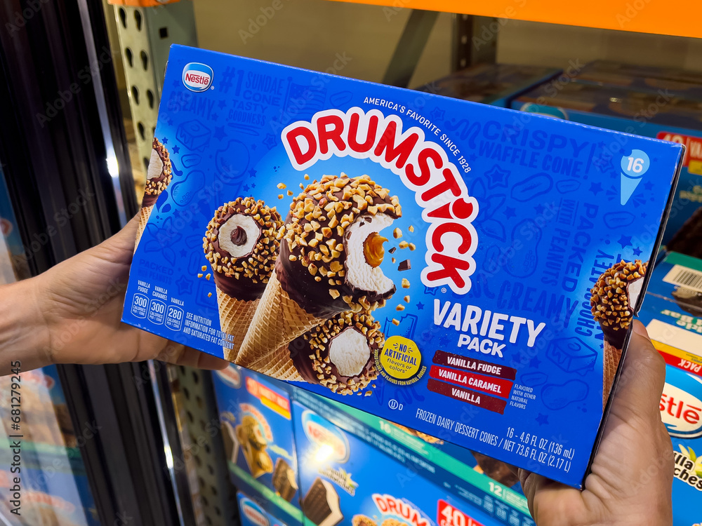 Shoppers hand holding a carton box of Nestle Drumstick brand ice cream
