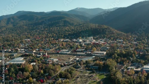 Ashland Downtown On Sunrise With Forested Mountains Background In Southern Oregon, USA. Aerial Pan Right Shot photo