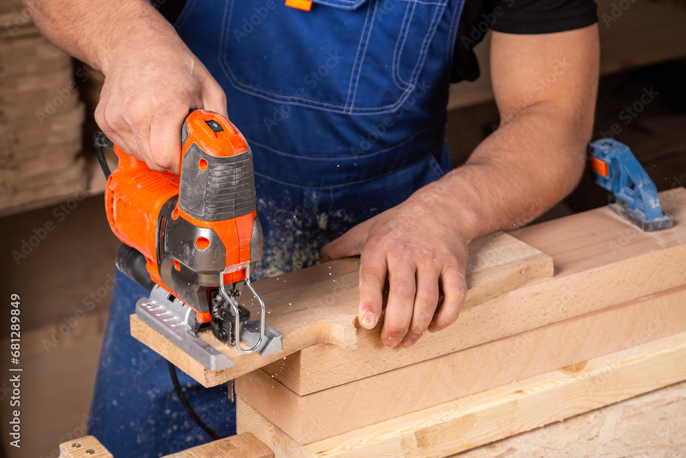 A carpenter using a jigsaw to cut wood cuts bars. A carpenter using a jigsaw to cut wood cuts bars.