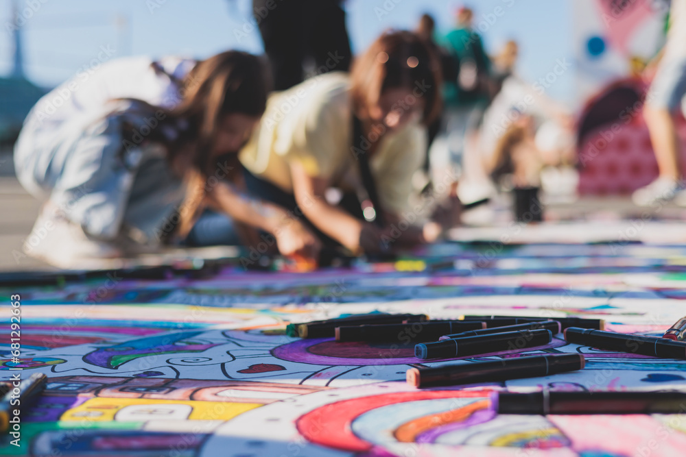 Naklejka premium Process of drawing on asphalt and pavement, kids and children with crayons, chalk and markers, teens creating street art on the ground, graffiti and pictures on sideways, street painting festival