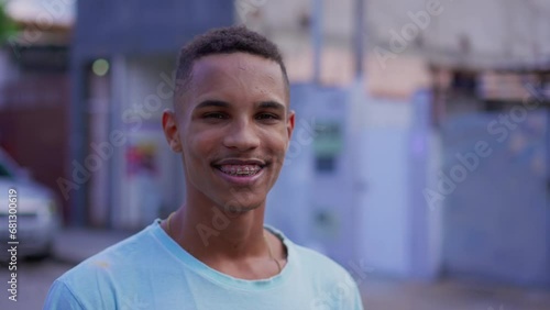 Portrait of a young black South American man smiling at camera, close-up face of a cheerful happy Brazilian individual with braces photo