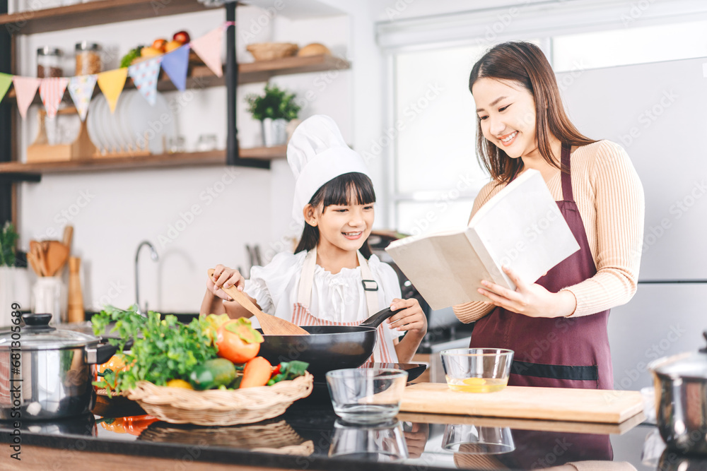 Mother and daughter cooking in kitchen preparation food for dinner meal, lifestyles together child with parent Mother and daughter cooking in kitchen preparation food for dinner meal, lifestyles together child with parent