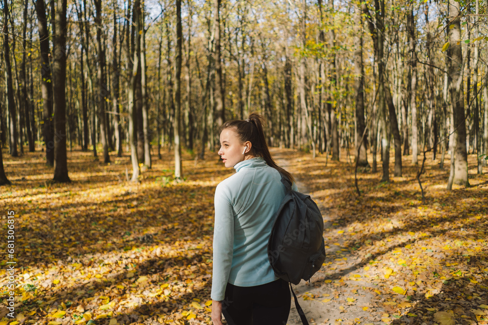 A girl in warm clothes walks through an autumn forest. Body positive, sports for women, harmony, healthy lifestyle, self-love and wellness. A girl in warm clothes walks through an autumn forest. Body positive, sports for women, harmony, healthy lifestyle, self-love and wellness.