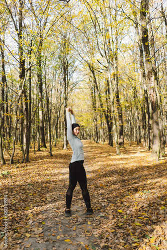 Beautiful girl doing fitness in nature on a sunny autumn forest. Body positive, sports for women, harmony, healthy lifestyle, self-love and wellness.