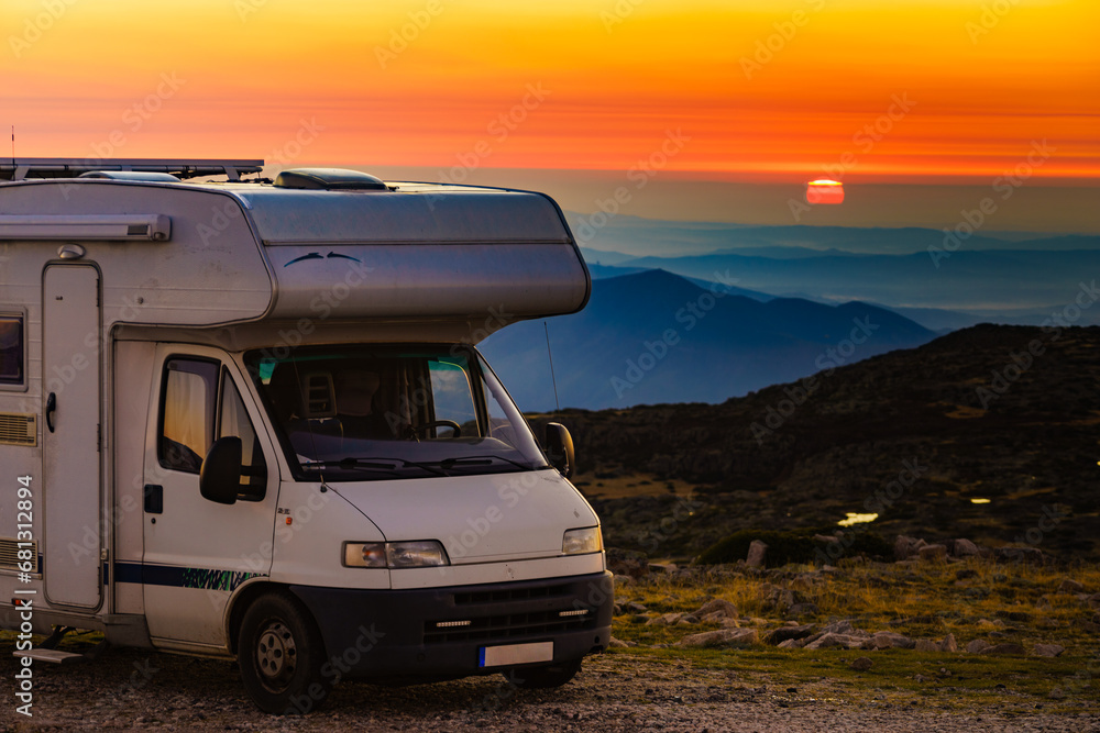 Rv camper camping in mountain at sunset.