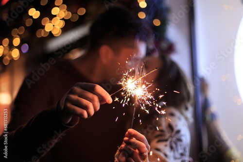 Beautiful couple holding sparklers celebrating christmas. Happy holiday