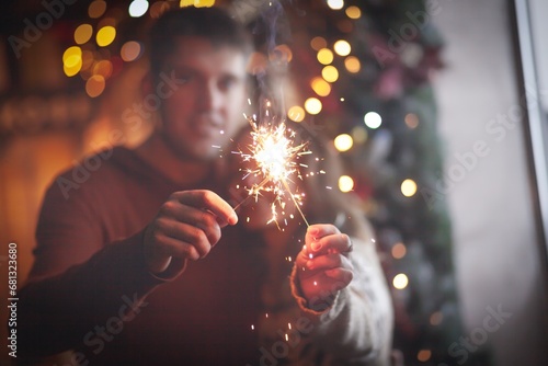 Beautiful couple holding sparklers celebrating christmas. Happy holiday