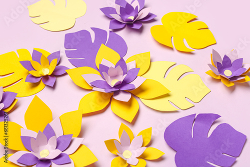 Colorful origami flowers and leaves on purple background