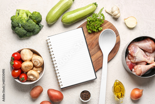 Composition with blank recipe book, fresh vegetables and chicken legs on light background