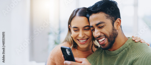 Love, hug and happy couple with phone in a house for social media, streaming or checking meme in their home together. Smartphone, app and people smile in a living room for funny gif, text or chat photo